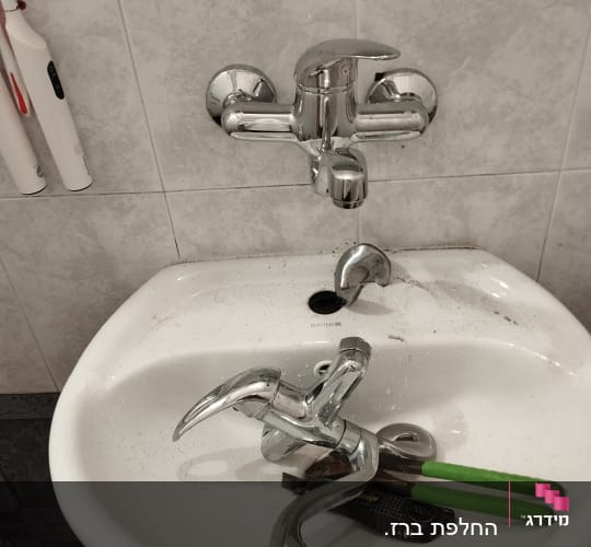 ברזים וכלים בכיור בחדר אמבטיה